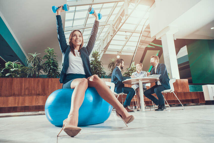 McCarron-Lake-Chiropractic-St-Paul-Chiropractor-Corporate-Wellness-Female-worker-exercising-on-fitness-ball-in-office